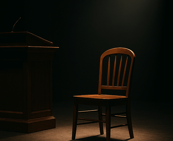 Empty wooden chair beside a pulpit under a warm spotlight, symbolizing the Executive Pastor role