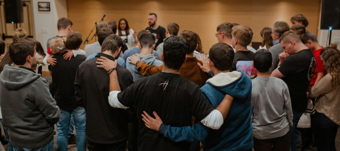 Church team praying together around a pastor in encouragement and support