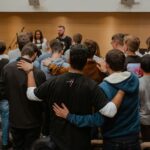 Church team praying together around a pastor in encouragement and support