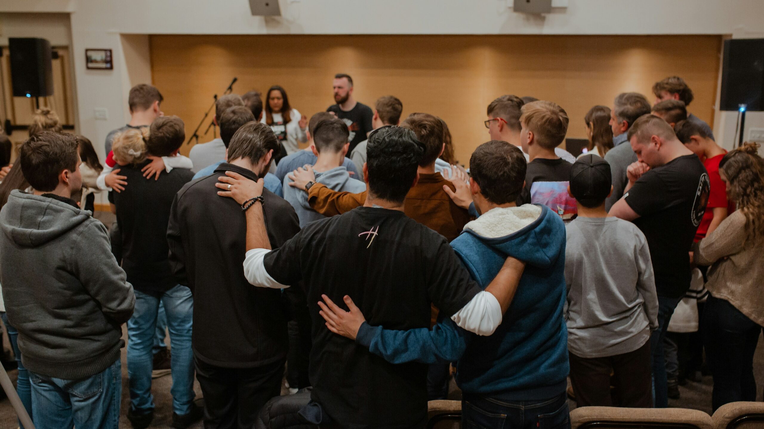 Church team praying together around a pastor in encouragement and support