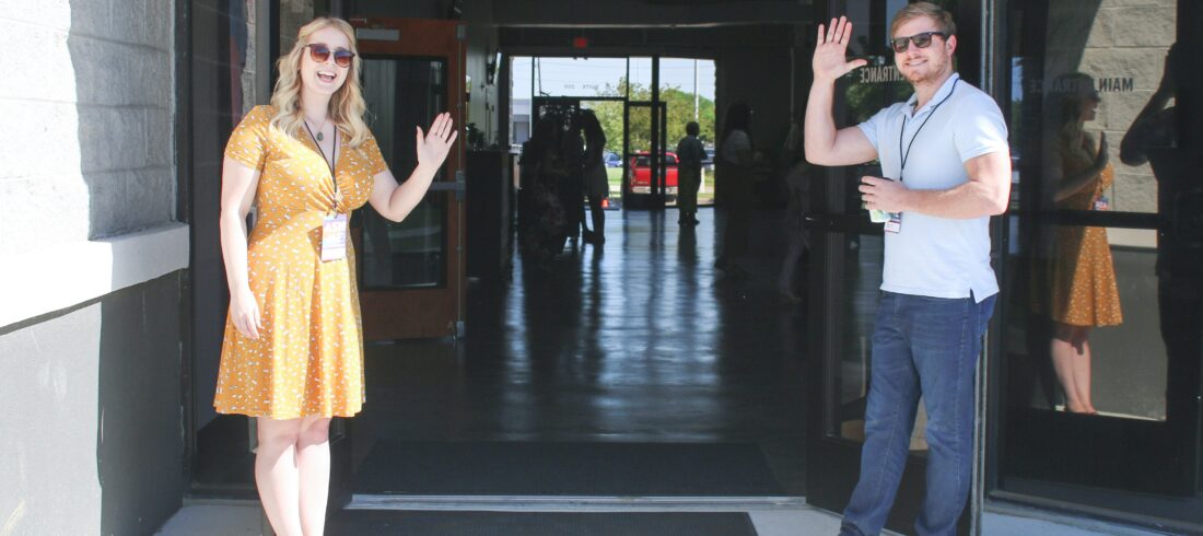 Church hospitality team greeting families at entrance for Easter outreach.