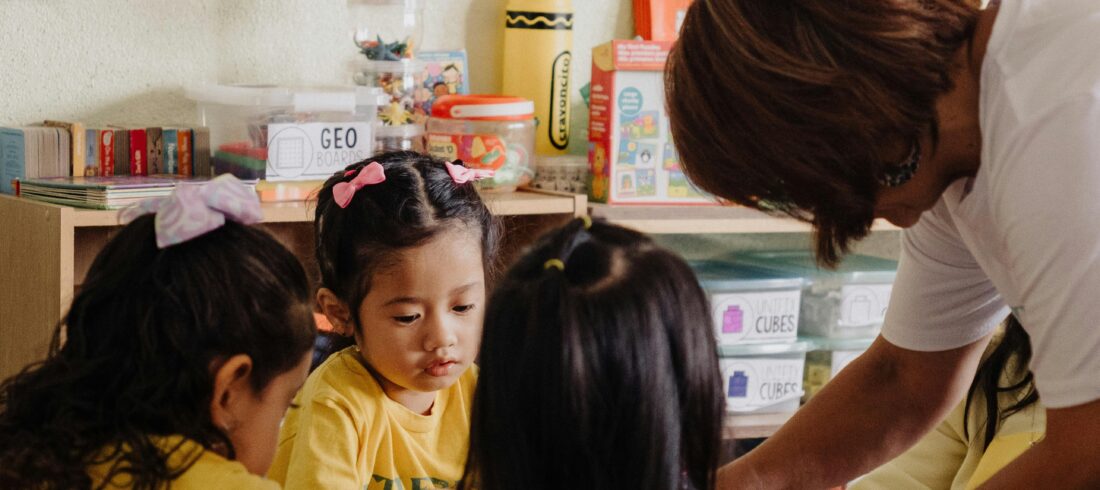 Kids ministry leader guiding children through an activity in a classroom setting, illustrating sustainable leadership practices that reduce kids ministry burnout.